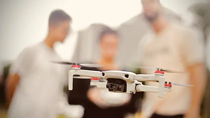 Drone em primeiro plano - aluno e instrutores do curso para pilotos de drone ao fundo