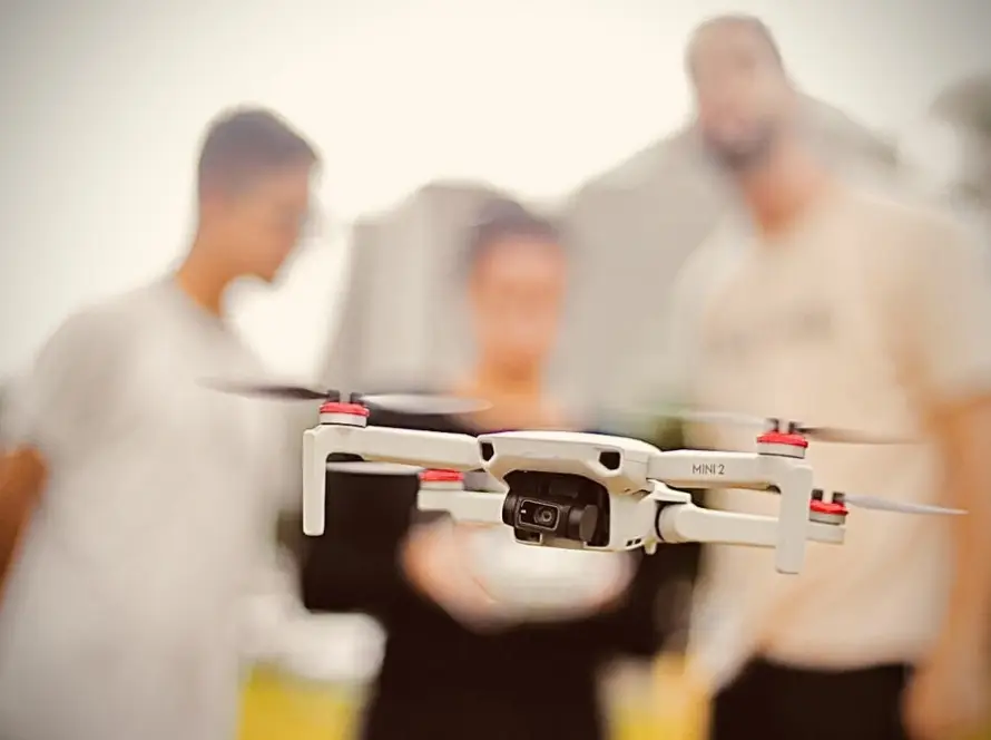 Drone em primeiro plano - aluno e instrutores do curso para pilotos de drone ao fundo